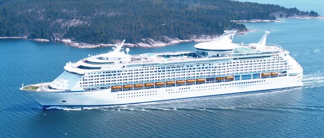 Royal Caribbean explorer of the seas best family cruise ship with trees in background yellow emergency boats on ship