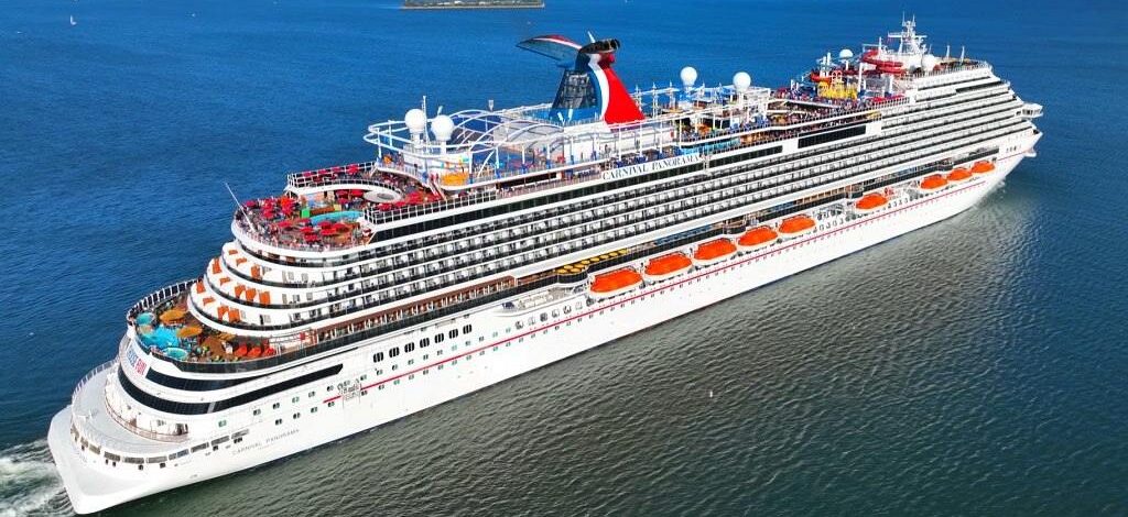 Aerial drone view of Carnival Panorama cruising at sea during a festive celebration.