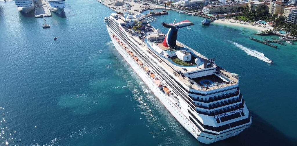 Aerial drone view of Carnival Freedom cruising at sea during a vibrant celebration
