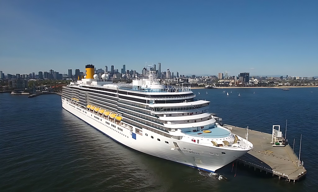 Aerial drone view of Carnival Luminosa cruising at sea during a festive celebration.