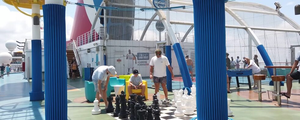 Carnival Sunrise - Game Deck - People are playing games like chess and basketball