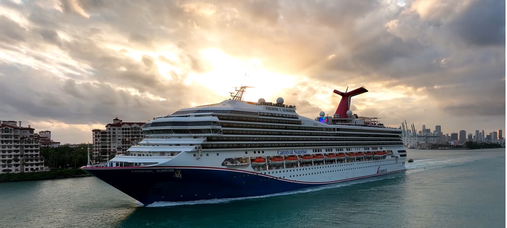 Aerial drone view of Carnival Sunrise cruising at sea during a festive celebration.